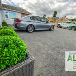 Modern family home with a spacious driveway, neatly parked vehicles, landscaped borders and an inviting entrance, illustrating how a well-designed driveway supports everyday family life during summer.