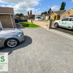 Light grey resin driveway installed by ALS Driveways at a residential property in Lincoln, showing smooth permeable resin-bound paving outside modern homes.